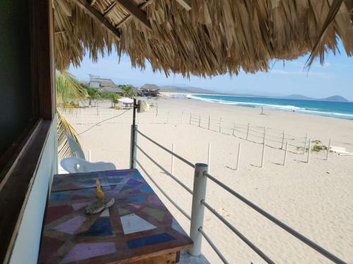 vistas a una playa con mesa y sillas en Cabañas Paraiso Chacahua, en Chamuscadero