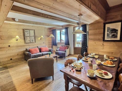 un salon avec une table avec de la nourriture dessus dans l'établissement Résidence Aquila - Superbe appartement 3 pièces cabine pour 8 personnes situé à Val d’Isère, skis aux pieds et à 500m du centre du village, navette MAE-2544, à Val dʼIsère