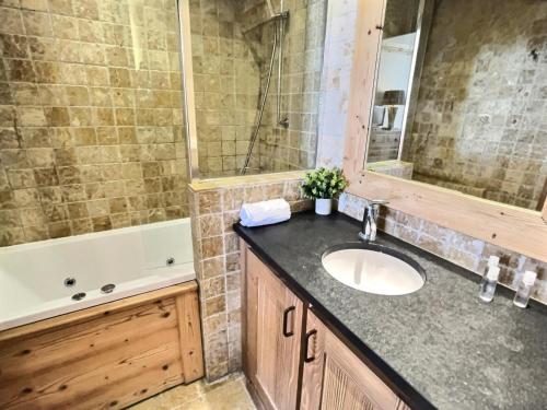 une salle de bain avec un lavabo et une baignoire dans l'établissement Résidence Aquila - Superbe appartement 3 pièces cabine pour 8 personnes situé à Val d’Isère, skis aux pieds et à 500m du centre du village, navette MAE-2544, à Val dʼIsère
