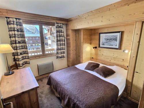 une chambre avec un grand lit et une fenêtre dans l'établissement Résidence Aquila - Superbe appartement 3 pièces cabine pour 8 personnes situé à Val d’Isère, skis aux pieds et à 500m du centre du village, navette MAE-2544, à Val dʼIsère