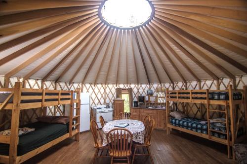 Cette chambre comprend une tente avec des lits superposés et une table. dans l'établissement Rivière Petit Saguenay, à Petit-Saguenay
