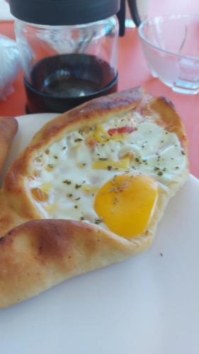 a slice of pizza with an egg on a plate at Guest House Narta in Vlorë