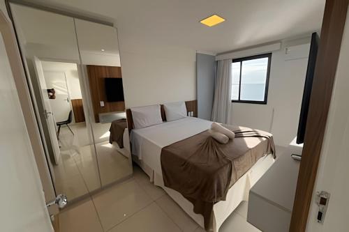 um quarto de hotel com uma cama e um chuveiro em Hosts BR - Flat frente mar c/ cozinha em Fortaleza