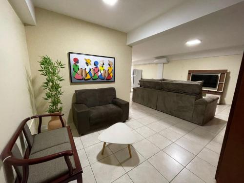 een woonkamer met een bank en een stoel bij Aquarius Alugueis in Goiânia