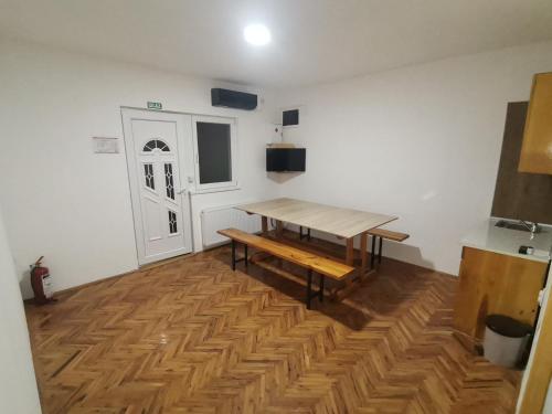 Zimmer mit einem Holztisch und Holzboden in der Unterkunft V&U Sobe in Brzi Brod
