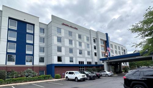 an office building with cars parked in a parking lot at Hampton Inn & Suites Tallahassee I-10-Thomasville Road in Tallahassee