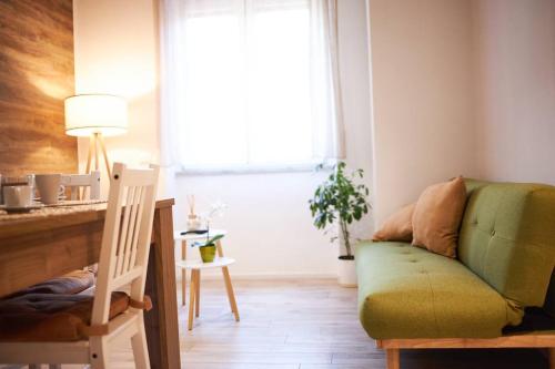 a living room with a green couch and a table at Plebiscito House in Castel di Sangro