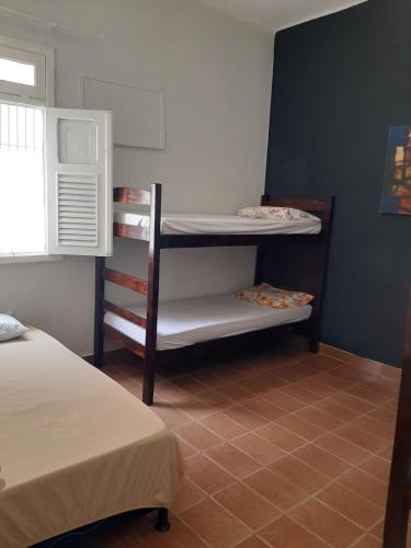 a small room with two beds and a bunk bed at Oxen Hostel 2024 in Recife