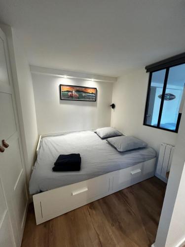 a bedroom with a bed in a white room at Logement avec piscine privée chauffée in Biarritz