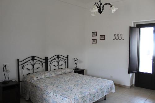 a bedroom with a bed in a white room at Trulli Nonna Grazia -miramonti in Cisternino