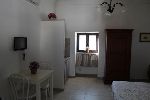 a bedroom with a bed and a table and a window at Trulli Nonna Grazia -miramonti in Cisternino