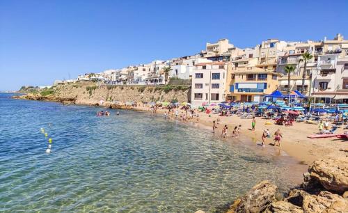 a group of people on a beach with buildings at SE LO SENTI LO SAI in Triscina