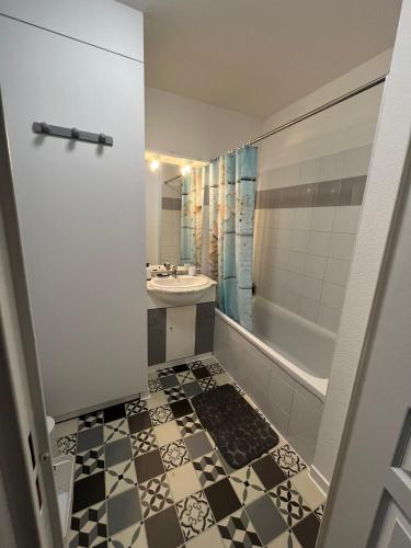 une salle de bain avec un lavabo, des toilettes et une baignoire dans l'établissement Appartement avec jardin à Rochefort, à Rochefort