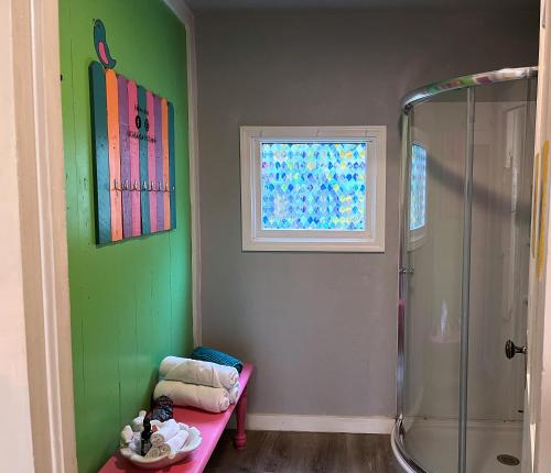 a bathroom with a shower and a pink bench at The Bluebird Cottage Style Cabin with Hot Tub near Turner Falls and Casinos in Davis