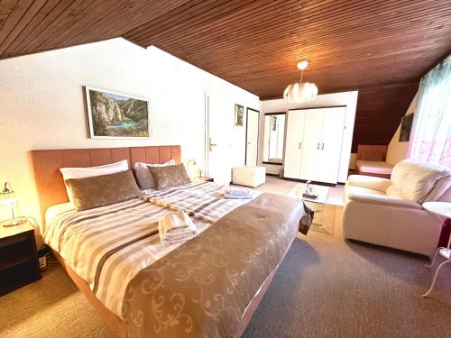 a bedroom with a large bed and a couch at Villa Mukinja - Wellness & Spa in Plitvička Jezera