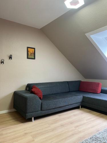 a living room with a blue couch and red pillows at S-VILLA Apartments im Schwarzwald in Schiltach