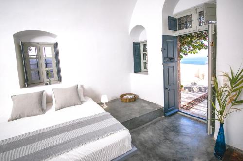 a bedroom with a bed and a door to a balcony at The Red Winehouse in Foinikiá