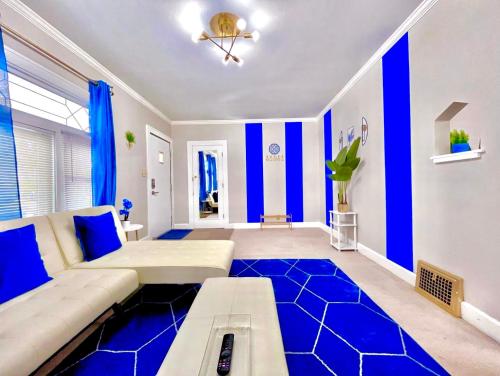 a living room with blue and white walls and a couch at The Sapphire Haven - Your Old Brooklyn Oasis Awaits Families, Couples, Business Travelers Near Downtown With Parking, 300 MB WiFi & Self Check-In in Cleveland