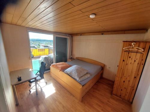 ein kleines Schlafzimmer in einem winzigen Haus mit einem Bett und einem Schreibtisch in der Unterkunft Feel comfortable II in Vaihingen an der Enz