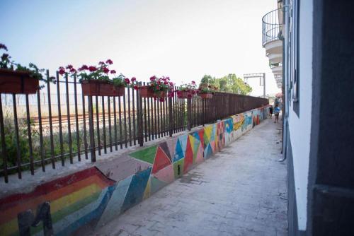 a fence with flowers on it next to a sidewalk at Il Vicoletto Bovalino - B&B in Bovalino Marina