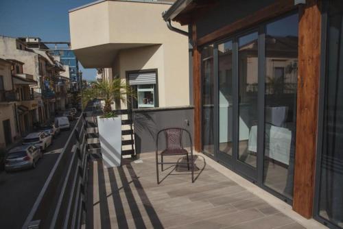 a balcony with a chair on the side of a building at Il Vicoletto Bovalino - B&B in Bovalino Marina