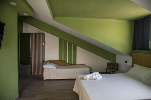 two beds in a room with green walls at Il Vicoletto Bovalino - B&B in Bovalino Marina