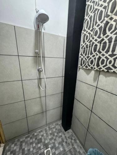 y baño con ducha con cabezal de ducha. en Habitación Ortencia, en San Salvador