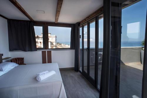 um quarto com uma cama e vista para o oceano em Il Vicoletto Bovalino - B&B em Bovalino Marina