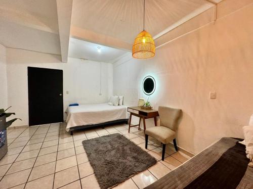 1 dormitorio con 1 cama, 1 mesa y 1 silla en Habitación Ortencia, en San Salvador