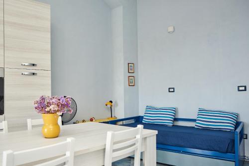 a dining room with a table and a blue couch at Casa Azzurra in Cala Gonone