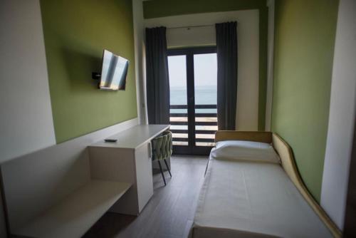 a room with a bed and a desk and a window at Il Vicoletto Bovalino - B&B in Bovalino Marina