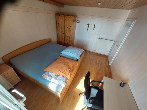 ein kleines Schlafzimmer mit einem Bett und einem Kreuz an der Wand in der Unterkunft Feel comfortable II in Vaihingen an der Enz