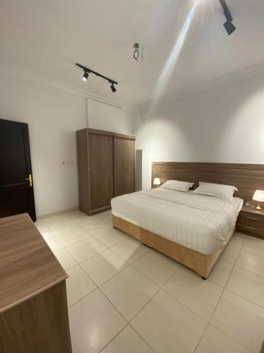 a bedroom with a large bed and a desk at بلانس للوحدات المفروشة in Tabuk