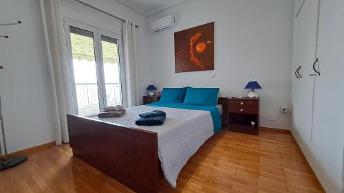 a bedroom with a bed with blue pillows on it at Tomis Sea View Apartment in Piraeus