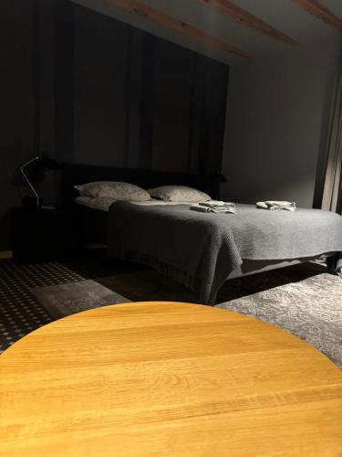 two beds in a dark room with a table at Garden House in Liepāja