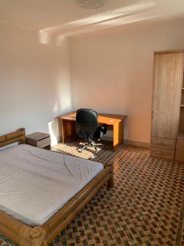 une chambre avec un lit, un bureau et une chaise dans l'établissement Chambre privée dans Maison d'hotes 10 minutes à pied de la gare et du centre, à Alès