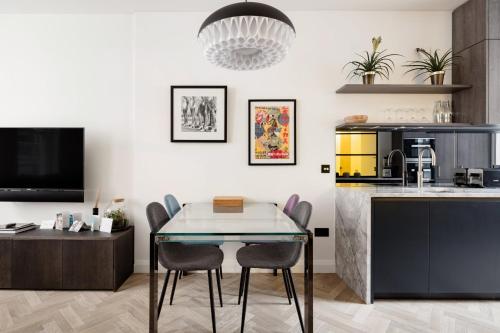 a kitchen and dining room with a table and chairs at Modern Apartment & Rooms at Charing Cross in London