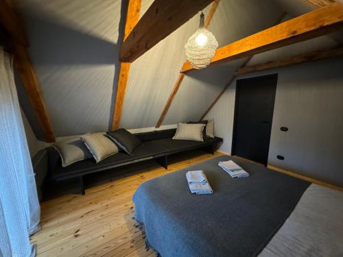 um quarto com uma cama e um sofá num sótão em Garden House em Liepāja