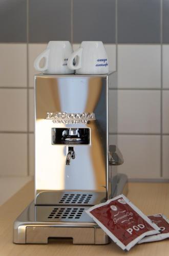 a coffee machine with two cups on top of it at Rückzugsort mitten im Paradies in Feldafing