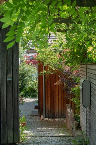 a garden with a wooden fence and a walkway at Rückzugsort mitten im Paradies in Feldafing
