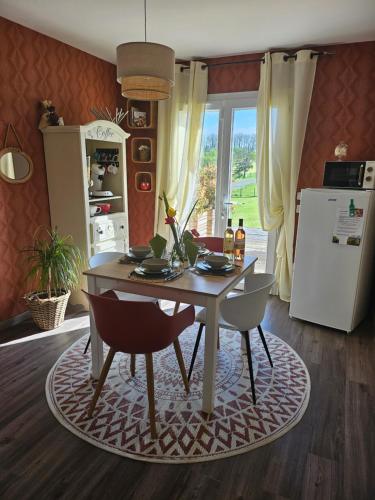 a kitchen with a table with chairs and a refrigerator at Millésime in Perville