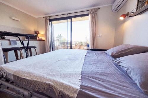 un grande letto in una stanza con una grande finestra di Studio standing - Village Lumio a Lumio