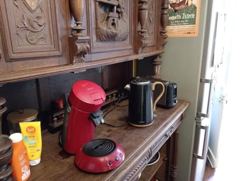 a kitchen counter with a red appliance on a counter top at Charmante et spacieuse maison de village in Courdemanche