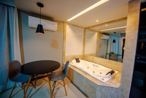 a bathroom with a sink and a table and chairs at HOTEL GRAN PREMIUM PLAZA LTDA in Muriaé