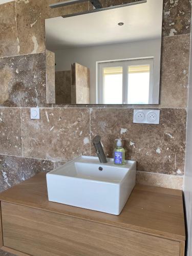 a bathroom with a white sink and a mirror at Chez prune in Rasteau