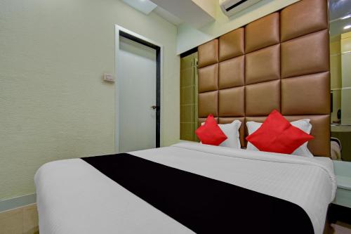 a bedroom with a large bed with red pillows at Super Collection O Snowfox in Kolkata