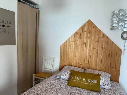 une chambre avec un lit avec une tête de lit en bois dans l'établissement Vue BAIE XXL 180°, au Crotoy