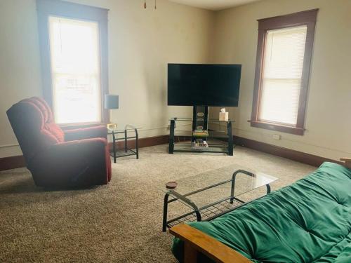 a living room with a couch and a flat screen tv at 2BR Erie Flat Remote Work Family-Friendly in Erie