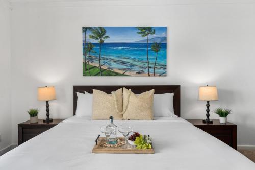 a bed with a tray of food and drinks on it at Kapalua Golf Villas 15T5 in Kahana