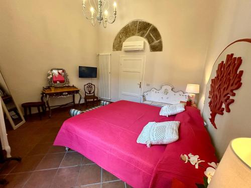 um quarto com uma cama vermelha e um cobertor rosa em Corallo Suite em Pisa